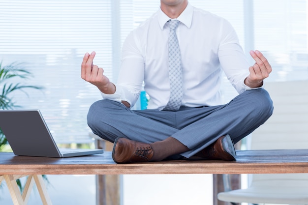 Zen businessman doing yoga meditation 