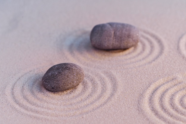 Zen garden stones on sand with ornament copy space