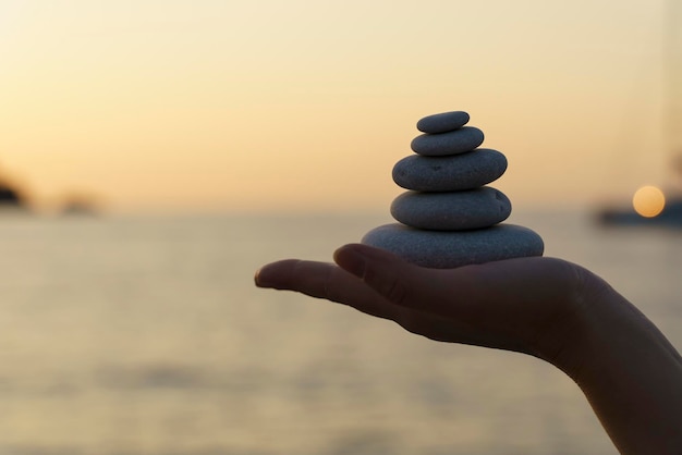 Zen stenen achtergrond Toren van stenen op het zeestrand op een zomeravond Meditatie kalmte vrede geestelijke gezondheid concept