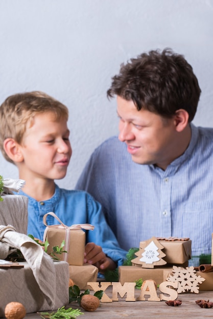 Concetto di natale a rifiuti zero padre e figlio che confezionano regali