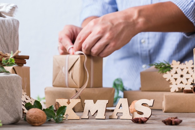 Zero waste christmas concept male hands wrapping gifts