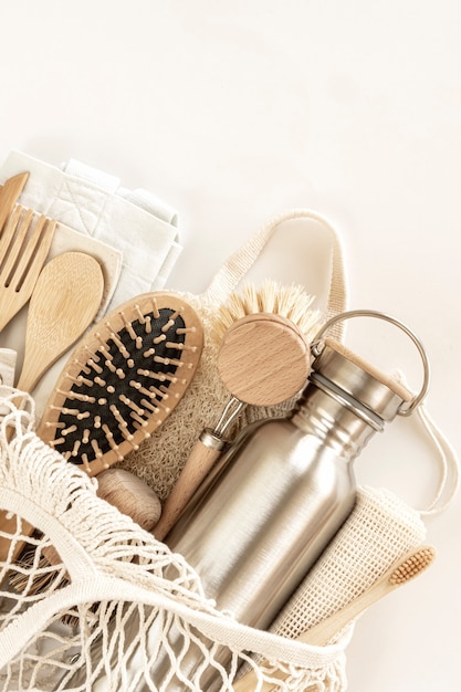 Zero waste concept. Eco-friendly accessories - bamboo cutlery, eco-friendly bag, reusable water bottle, hairbrush and toothbrush. No plastic, eco-friendly lifestyle. Top view, flat lay.