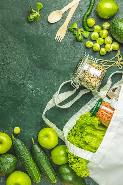 Zero waste concept Ecovriendelijke winkel plat lag Verse biologische groene groenten en fruit op groene achtergrond Lente dieet gezond rauw vegetarisch veganistisch concept alkalisch schoon eten