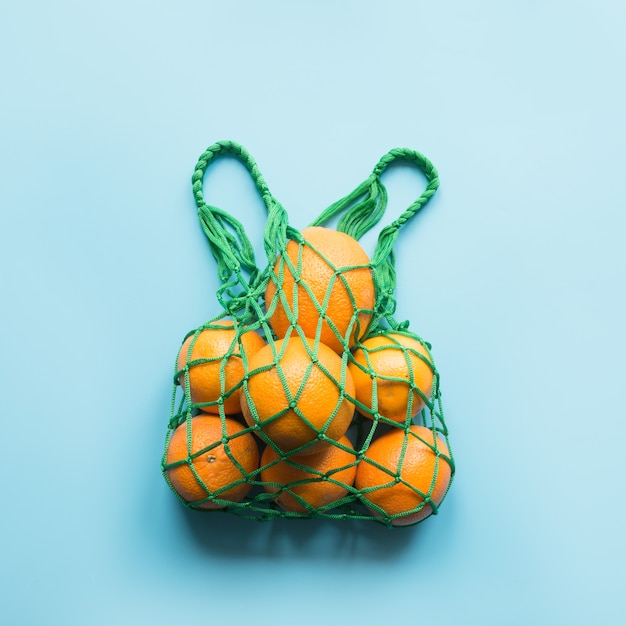 Zero waste concept. Green shopping bag with orange.