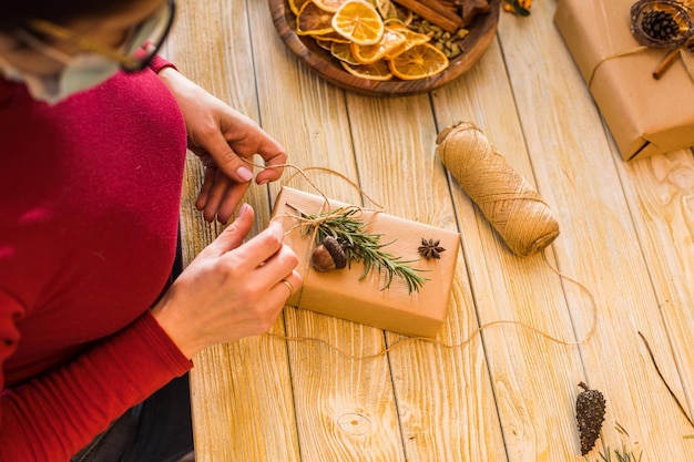 Zero waste and eco style recycled gifts Woman is packing aroma craft box with rosemary and pine cone