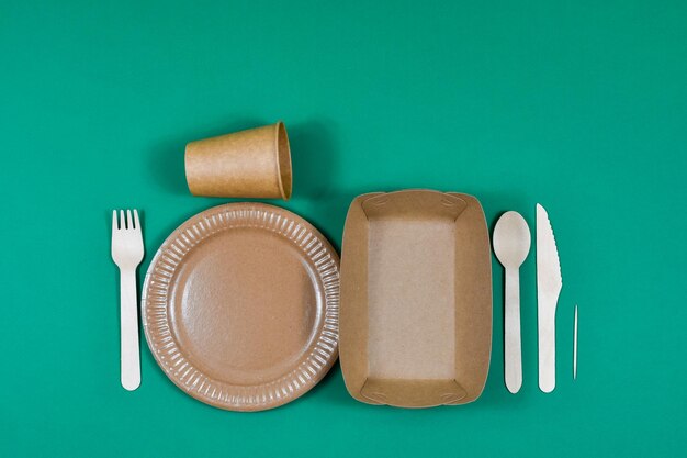 Zero waste ecofriendly disposable cardboard paper utensils on a green background