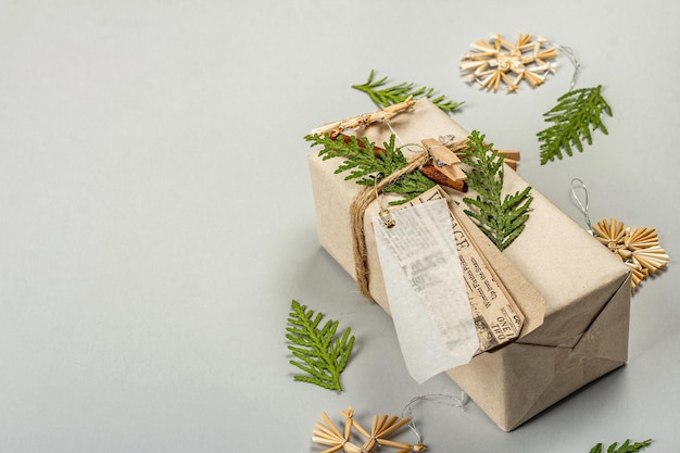 Zero waste gift concept. Christmas or New Year eco-friendly packaging. Festive boxes in craft paper with different organic decorations. Light grey background, flat lay, copy space