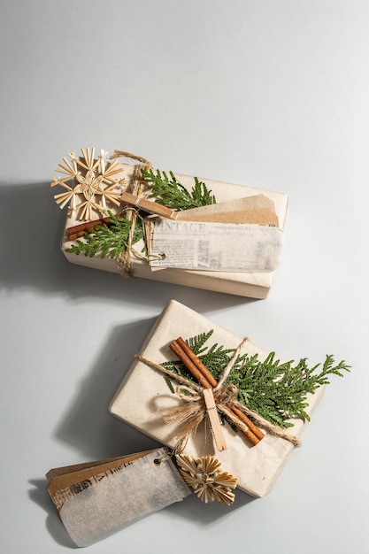 Zero waste gift concept. Christmas or New Year eco-friendly packaging. Festive boxes in craft paper with different organic decorations. Trendy hard light, dark shadow, flat lay, top view