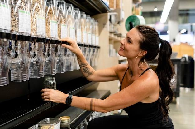 Zero waste shopping image, woman buying cereal with BYO jar