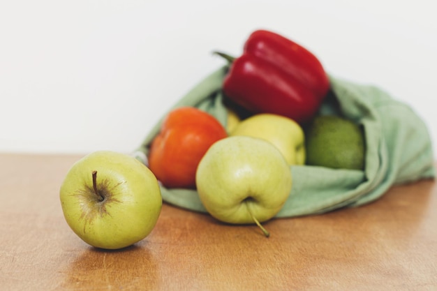 Zero waste shopping Verse appels avocado tomaten peper in katoenen zak op houten tafel