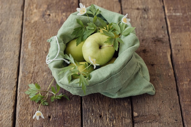 Foto zero waste shopping verse appels en bloemen in eco-katoenen zak op rustiek hout duurzame levensstijl