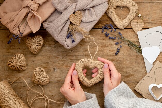 Zero waste Valentine's Day concept and mock up. gift packaged furoshiki style with lavender, pampas grass jute and stencil hearts. Top view or flat lay. Instruction, step by step