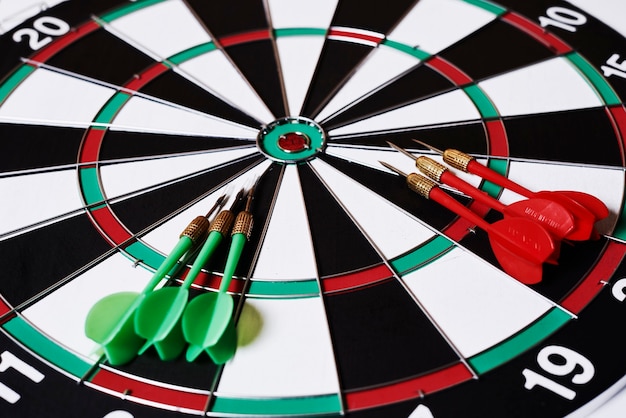 Zes darts liggen op een dartbord