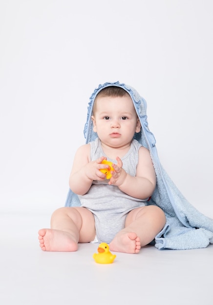 Zes maanden baby met handdoek na bad Kinder- en babyverzorgingsconcept