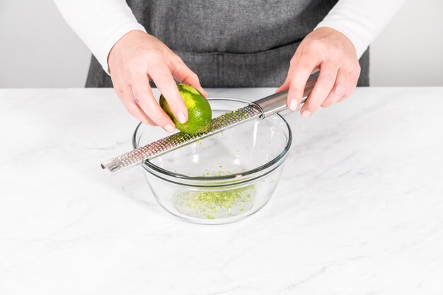 Zesting fresh lime  to prepare chili lime salt for Mexican watermelon pops.