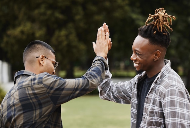 Zet het bovenaan Shot van twee jonge mannen die elkaar een high five geven op de campus
