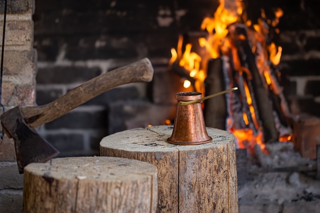 Zet koffie in een Turk op open vuur. Het concept van een gezellige sfeer en drankjes.