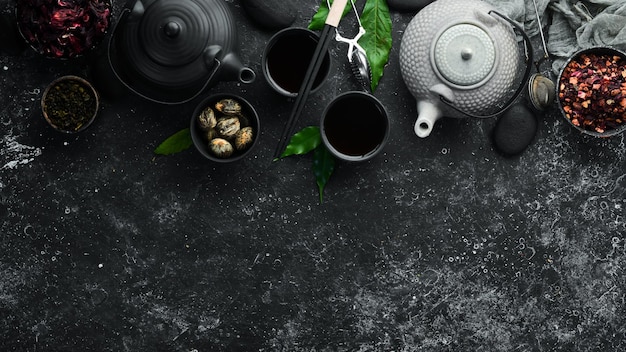 Zet traditionele Chinese thee op zwarte stenen achtergrond Thee in theepot en kopje Bovenaanzicht vrije ruimte voor uw tekst