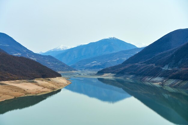 Photo zhinvali reservoir in the mountains of georgia. azure water on a background of mountains.