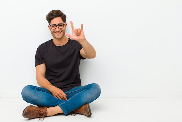 Zich gelukkig, leuk, zelfverzekerd, positief en rebels voelen, met de hand rock- of heavy metal-bord maken