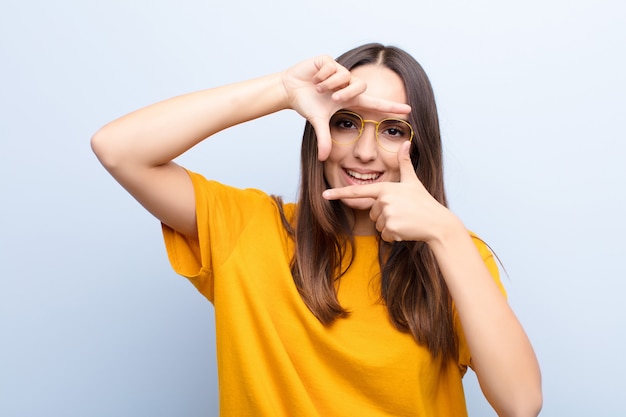 zich gelukkig, vriendelijk en positief voelen, glimlachen en met handen een portret of fotolijst maken