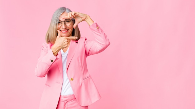 zich gelukkig, vriendelijk en positief voelen, glimlachen en met handen een portret of fotolijst maken