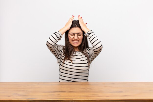 Zich gestrest en angstig voelen, depressief en gefrustreerd door hoofdpijn, waarbij beide handen tegen het hoofd worden geheven