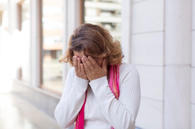 Zich verdrietig voelen gefrustreerd nerveus en depressief gezicht bedekken met beide handen huilen