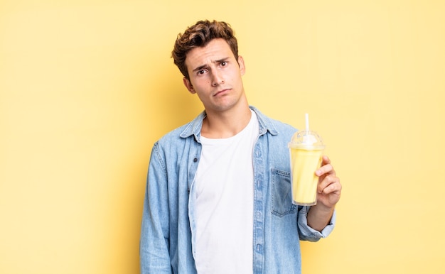 Zich verward en verward voelen, met een stomme, verbijsterde uitdrukking op zoek naar iets onverwachts. milkshake concept