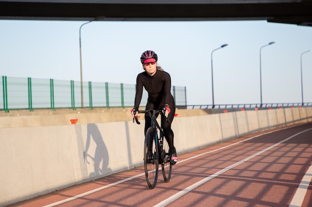 Zicht op de fietser in de stralen van de zonsondergang