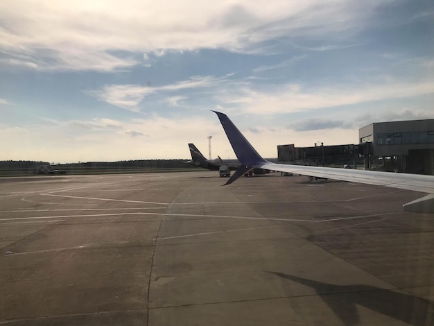 Zicht op de vleugel vanuit het raam van een vliegtuig boven de landingsbaan