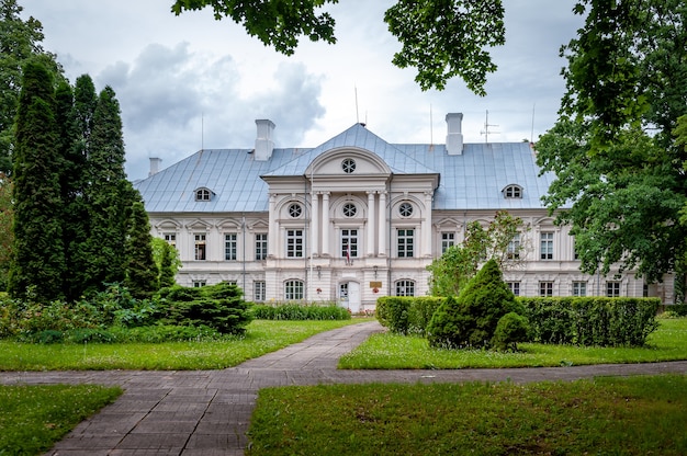Zicht op het witte kasteel door het park. Zalenieki Manor, Green Manor, Letland.
