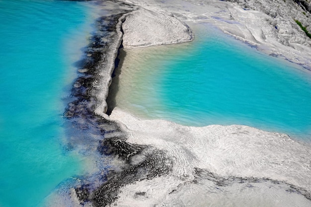 Zicht op natuurlijke terrassen in Pamukkale op een zomerdag Close-up textuur van kalksteen en water dat eroverheen stroomt