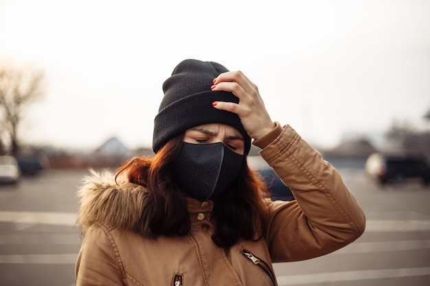 Ziek ziek meisje in zwart masker angstige vrouw in masker lijdt aan hitte, hoofdpijn worstelt op straat, zich slecht voelen. Persoon heeft hulp nodig. Virus, Chinees pandemisch coronavirus, paniekconcept.