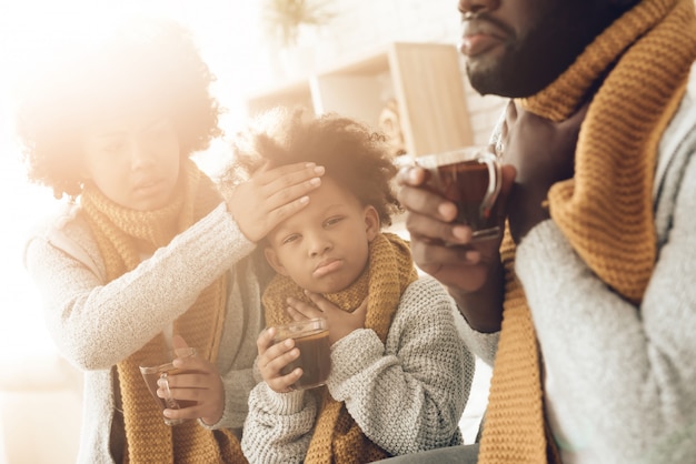 Zieke Afrikaanse familie met keelpijn die op bed thuis zitten