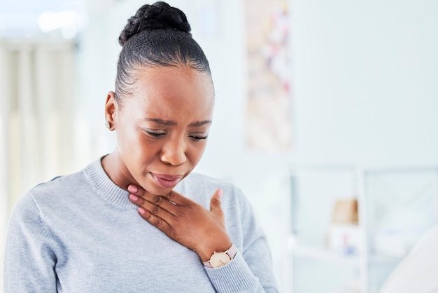 Zieke borst en zwarte vrouw met keelpijn thuis voor griepverkoudheid of allergieën op muurachtergrond Hoesttuberculose en Afrikaanse dame verstikkingsinfectie of ademhalingslong of probleem