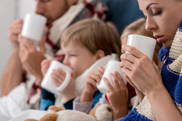 zieke jonge familie die verwarmende dranken in bed drinkt