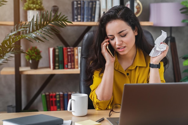 Zieke jonge vrouw met verkoudheid praten op mobiele telefoon met weefsel voor griepvirus