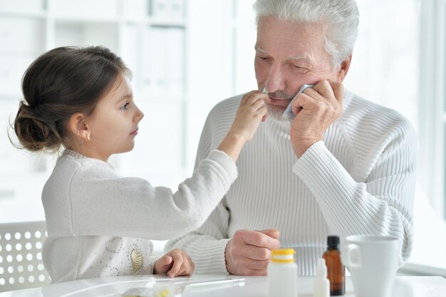 Zieke kleindochter met opa die thuis zit