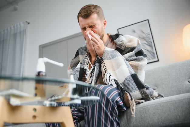 Zieke man op de bank thuis en snuitneus