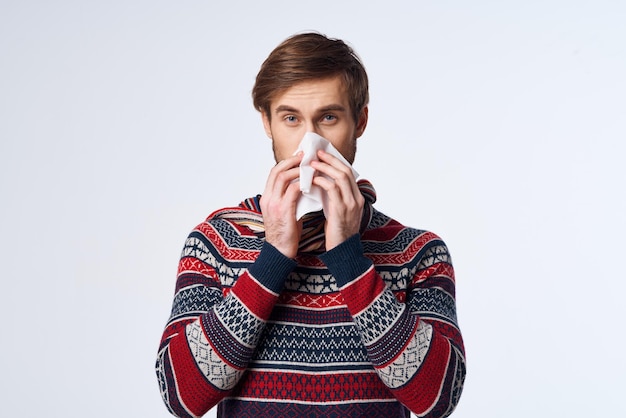 Zieke man trui gezondheidsproblemen zakdoek griepinfectie lichte achtergrond foto van hoge kwaliteit