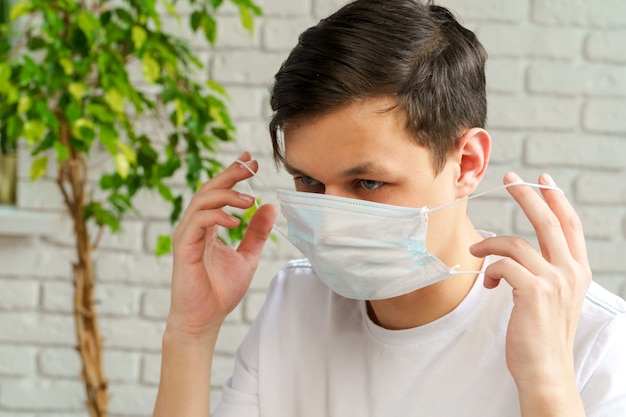 Zieke mens met medisch beschermend masker op zijn gezicht dat in bureau werkt. Coronavirus concept van uitbraak