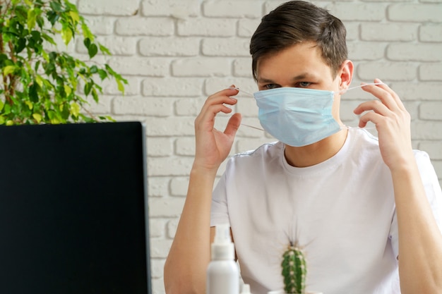 Foto zieke mens met medisch beschermend masker op zijn gezicht dat in bureau werkt. coronavirus concept van uitbraak