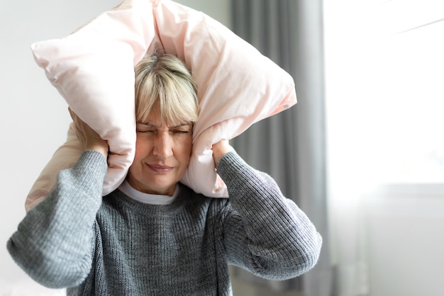 Zieke ongelukkige senior volwassen oudere vrouw die haar hoofd ernstig depressief aanraakt en hoofdpijn voelt, denkend aan problemen thuis, fysieke migraine en gezondheidszorgprobleem