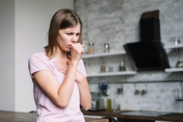 Foto zieke vrouw die hoest thuis