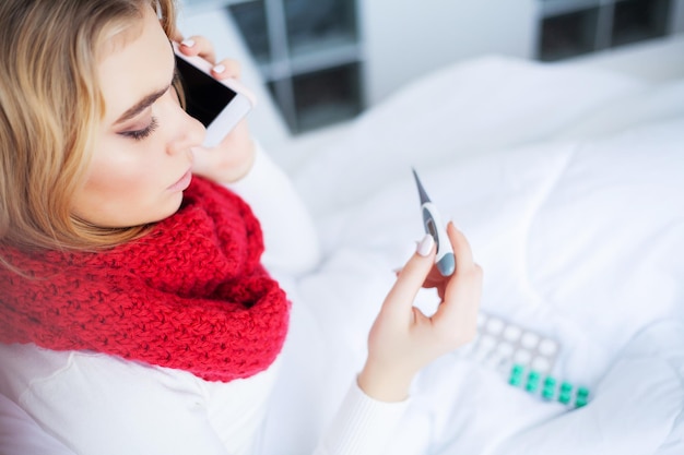 Zieke vrouw in bed meet temperatuur