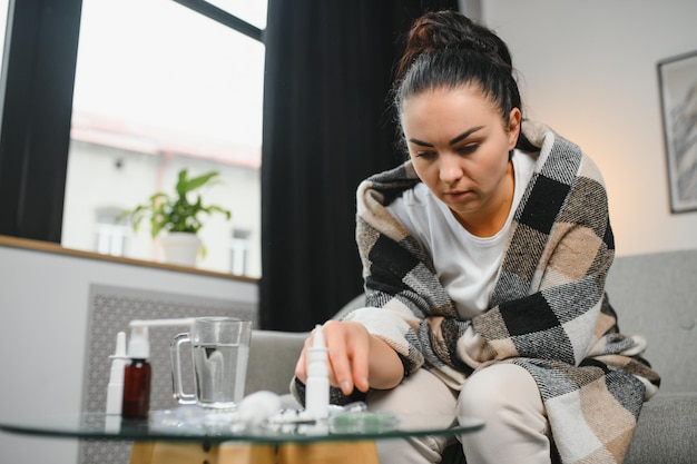 Zieke vrouw met hoofdpijn, zittend onder de deken