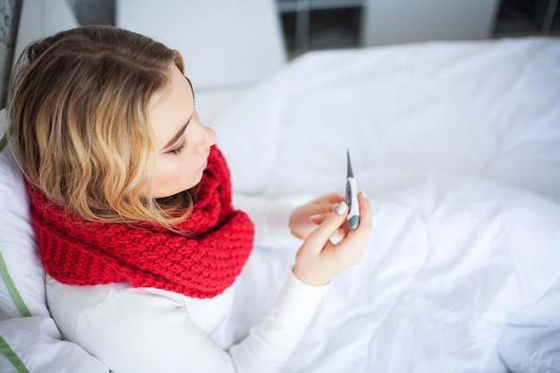 Zieke vrouw met verkoudheid wordt thuis in bed behandeld