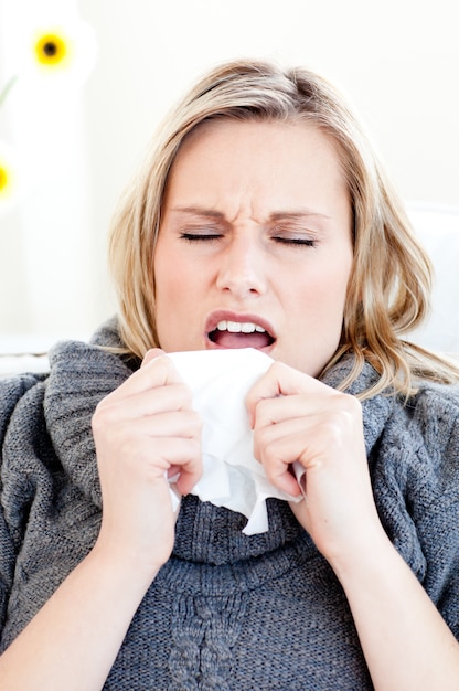 Zieke vrouw niezen met een tissue