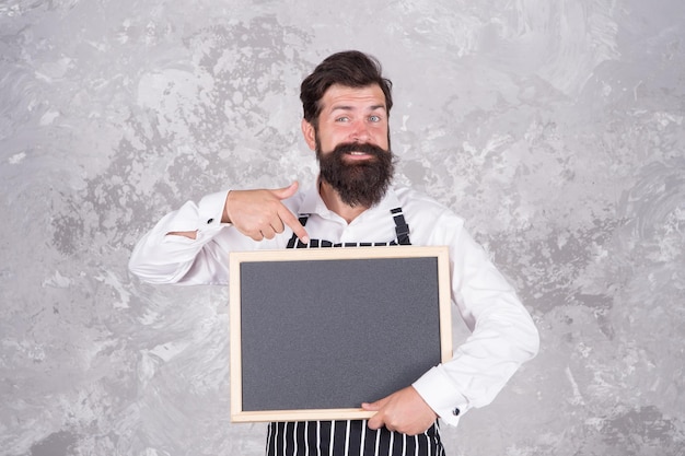 Zien er fantastisch uit. beste keuken hier. welkom aan boord. brutale man hipster houdt schoolbord vast, kopieer ruimte. koffie om mee te nemen. beste prijs in de stad. gelukkige bebaarde chef-kok wijzende vinger. succesvolle kokscarrière.